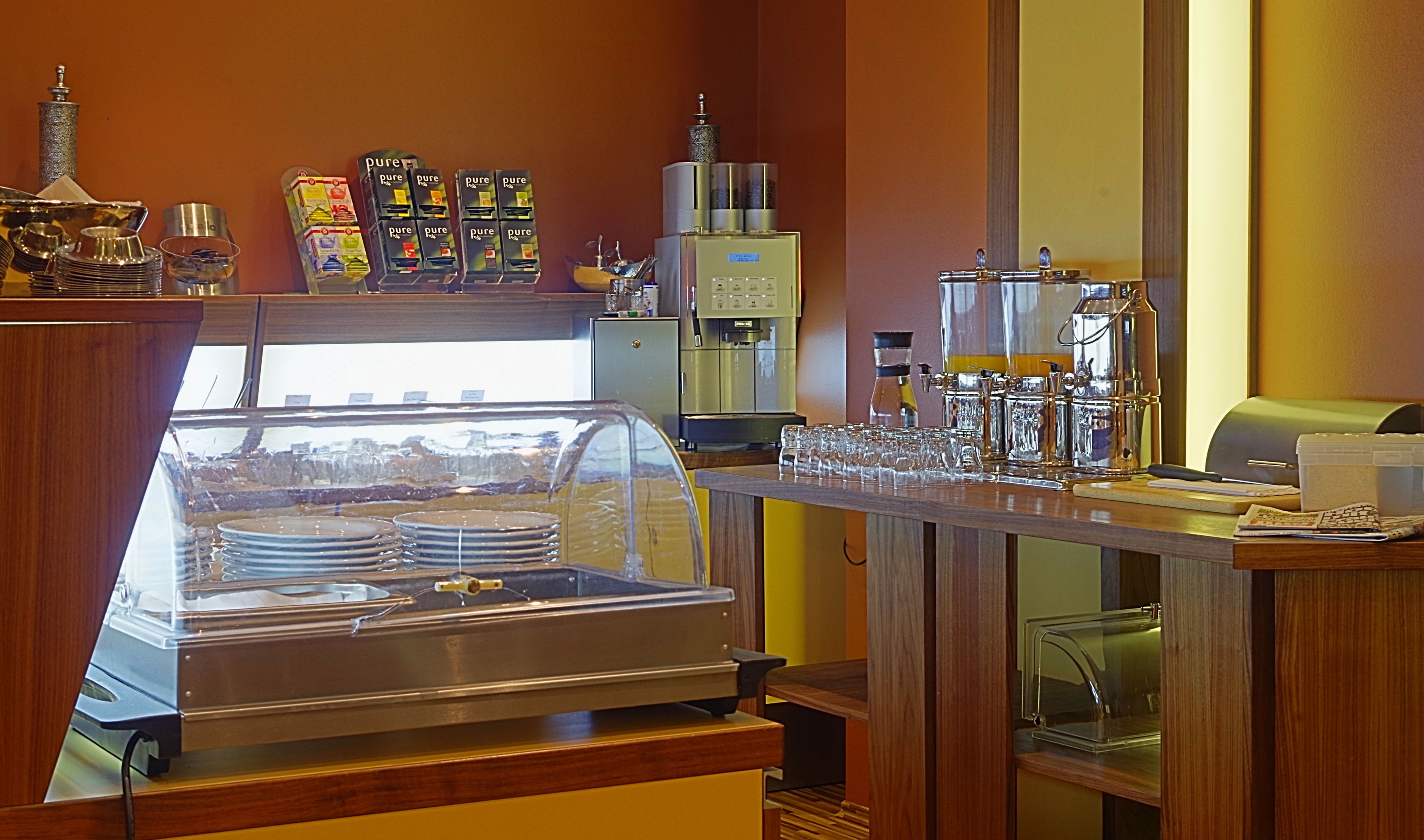A buffet area with a variety of food items, a coffee machine, and a coffee station.