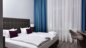Una habitación de hotel con una cama grande, un escritorio y una silla.