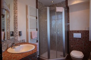 A bathroom with a stone sink, a glass shower enclosure, and a toilet. - Hotel Heide Residenz (Paderborn)