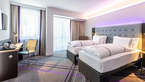 A hotel room with two beds, a desk, and a chair. - Premier Inn Passau Weisser Hase (Passau)