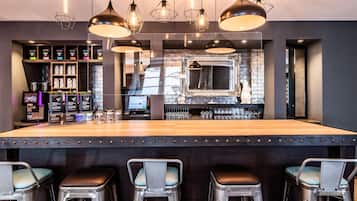 Un espace bar avec des tabourets, un comptoir et un présentoir à verres.