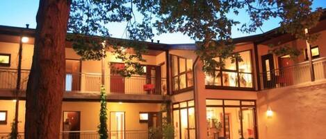 A multi-story hotel with balconies, large windows, and a courtyard.