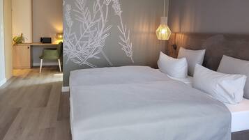 A bedroom with a bed, a desk, and a chair.