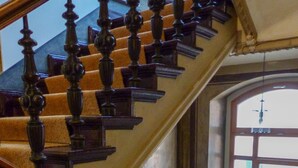 A grand staircase with ornate balusters and a checkered carpet. - Hotel Sachsenhof Berlin (Berlin)