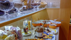 A buffet with various food items including waffles, bowls of different sauces, and packaged snacks. - Hotel Sachsenhof Berlin (Berlin)