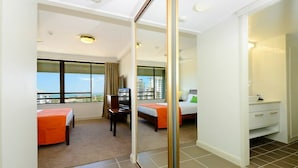 A hotel room with two beds, a desk, and a large mirror. - Marrakai Apartments (Darwin)