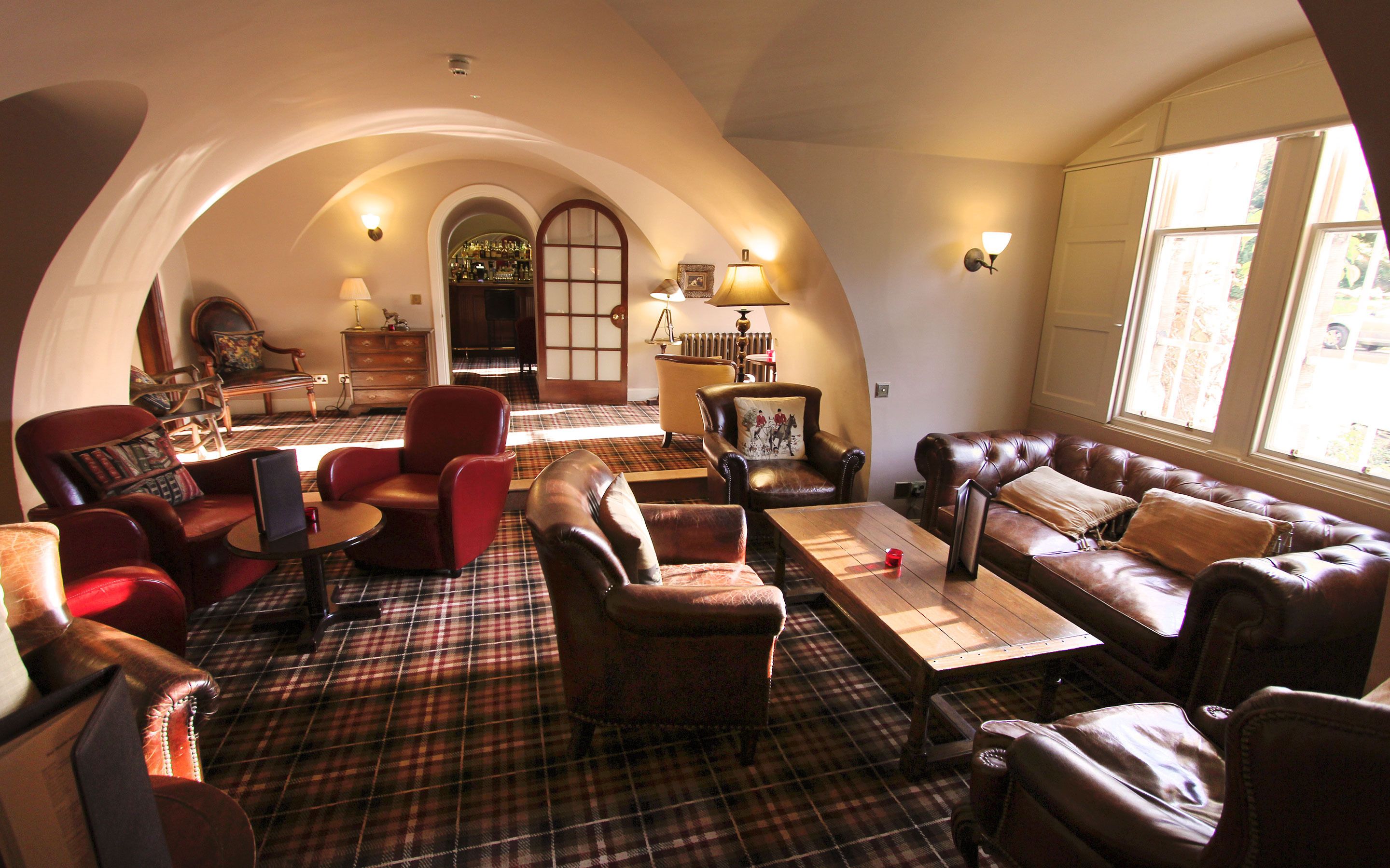 A cozy living room with a checkered floor, leather sofas, and a fireplace.