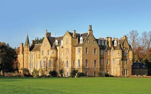 A large, historic stone building with multiple towers and a symmetrical facade, surrounded by a well-maintained lawn. - Carberry Tower Mansion House and Estate (Musselburgh)
