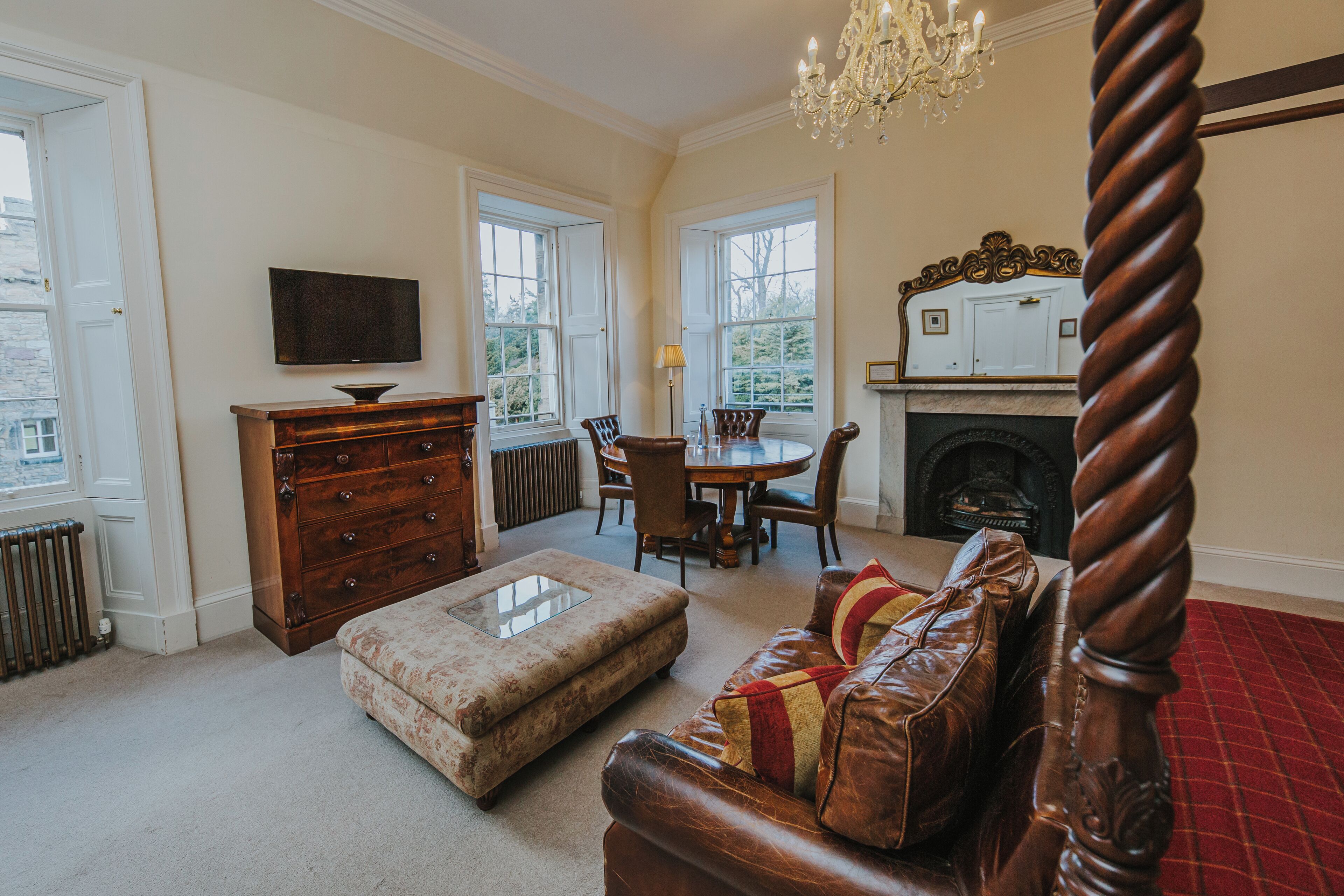A traditional room with a fireplace, a dining table, and a television.