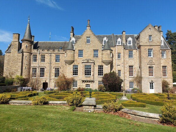 A large stone building with multiple towers and a well-maintained garden in front. - Carberry Tower Mansion House and Estate (Musselburgh)