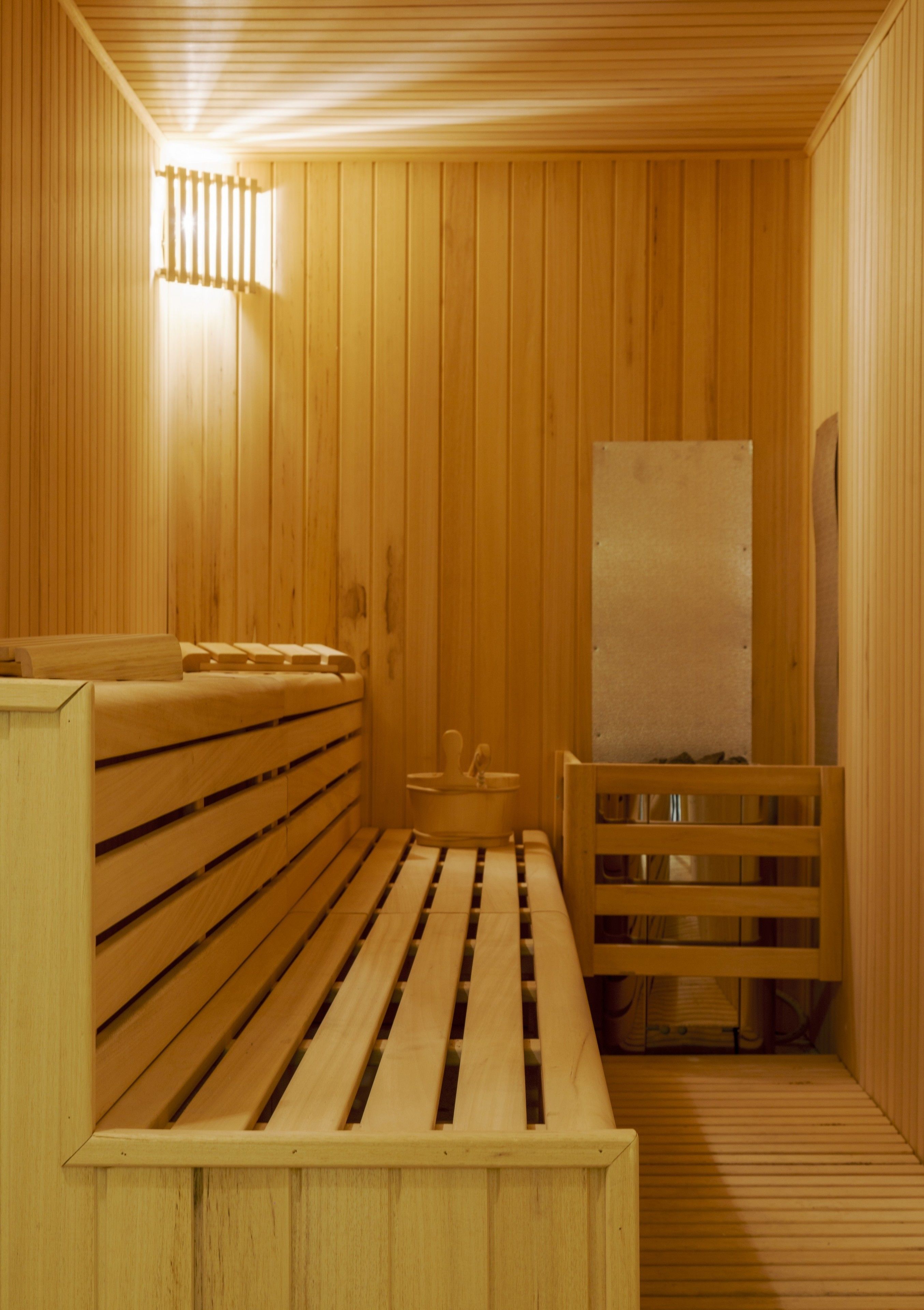 Una sauna de madera con bancos y un asiento de banco.