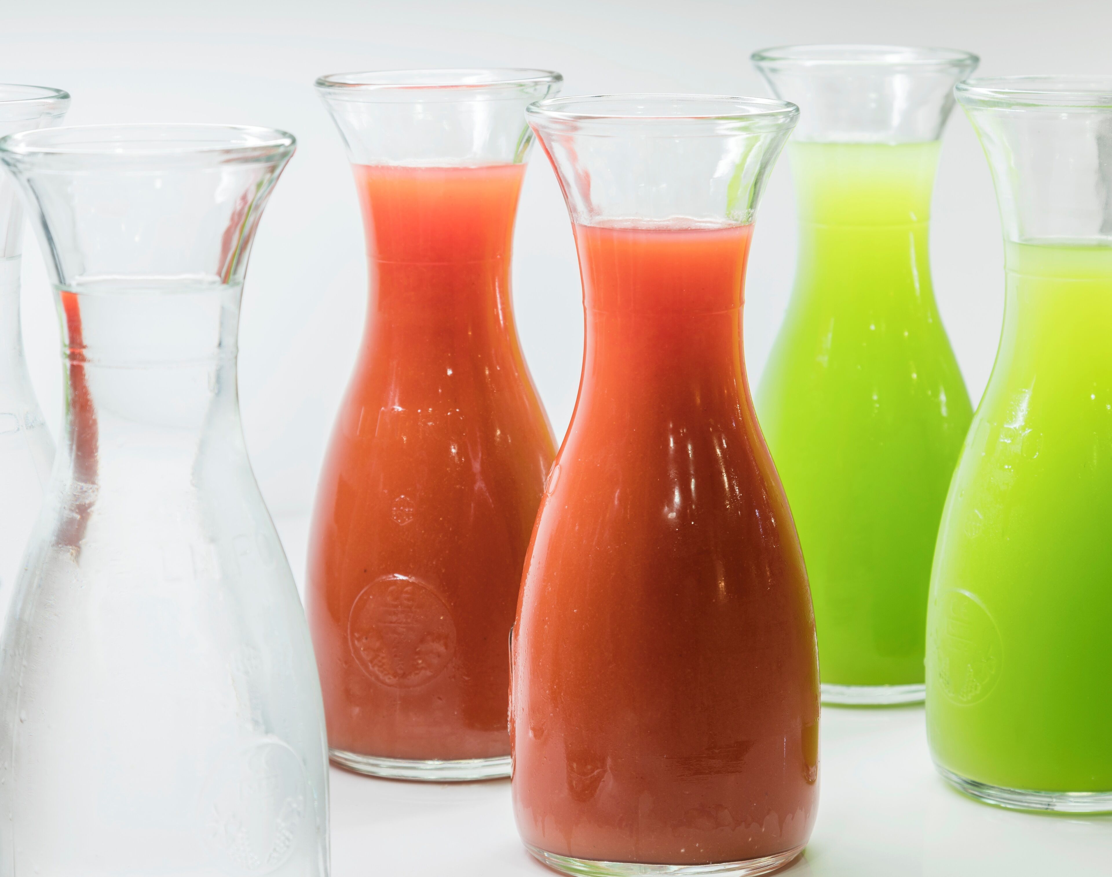 Four glass bottles with different colored liquids.