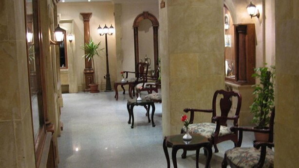 A lobby with a marble floor, wooden furniture, and a large mirror. - Philippe Luxor Hotel (Luxor)