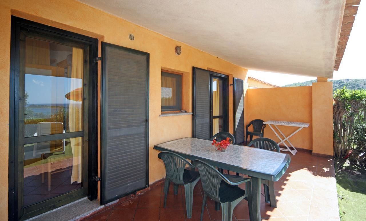 A patio with a table and chairs, a sliding door, and a view of the outdoors.