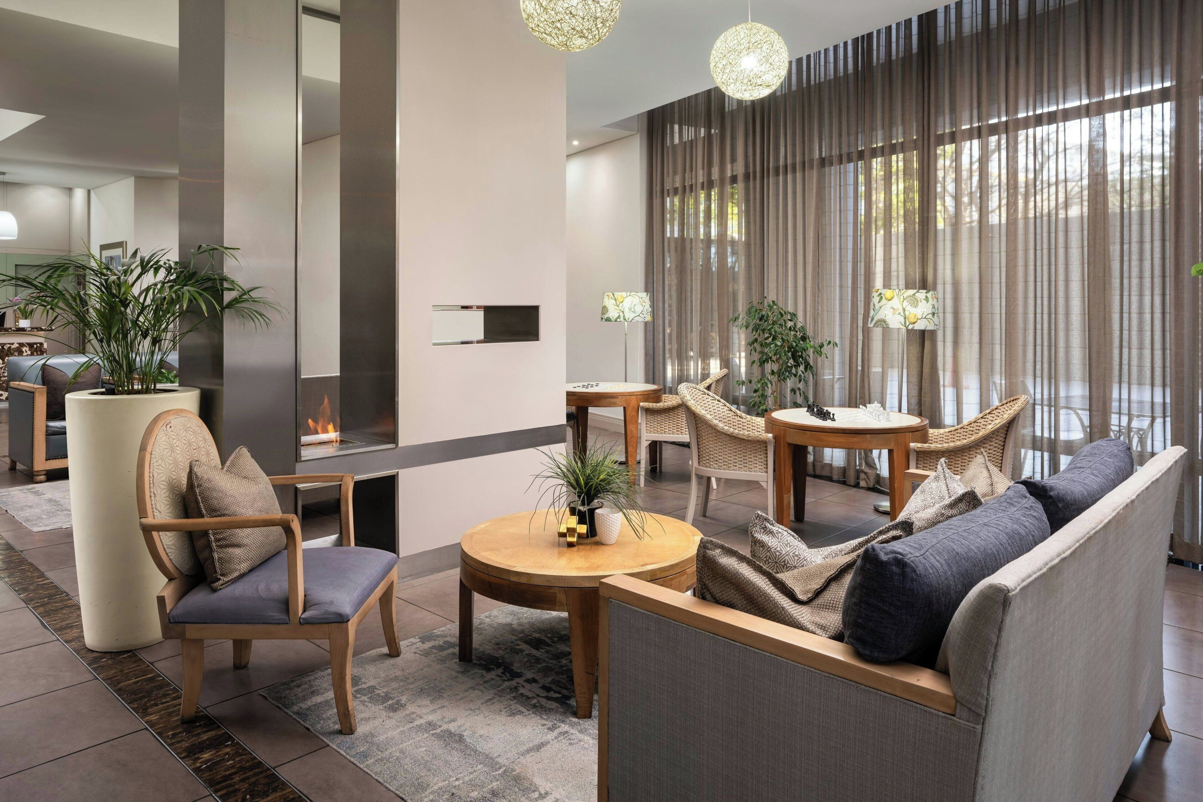 Un salon moderne comprenant un canapé, des fauteuils, une table ronde et une cheminée.