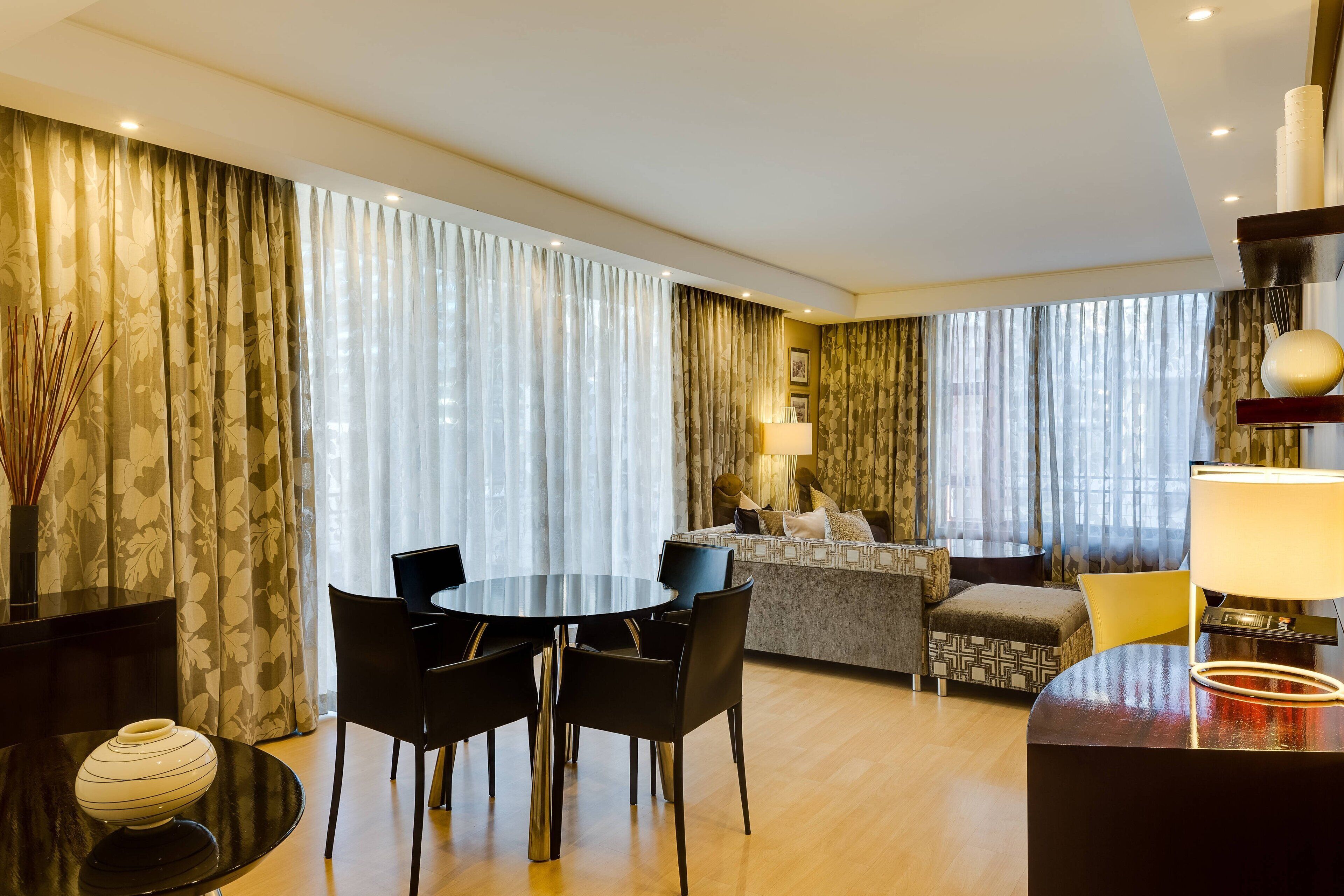 Ett modernt hotellrum med en matplats, en soffa och en lampa.