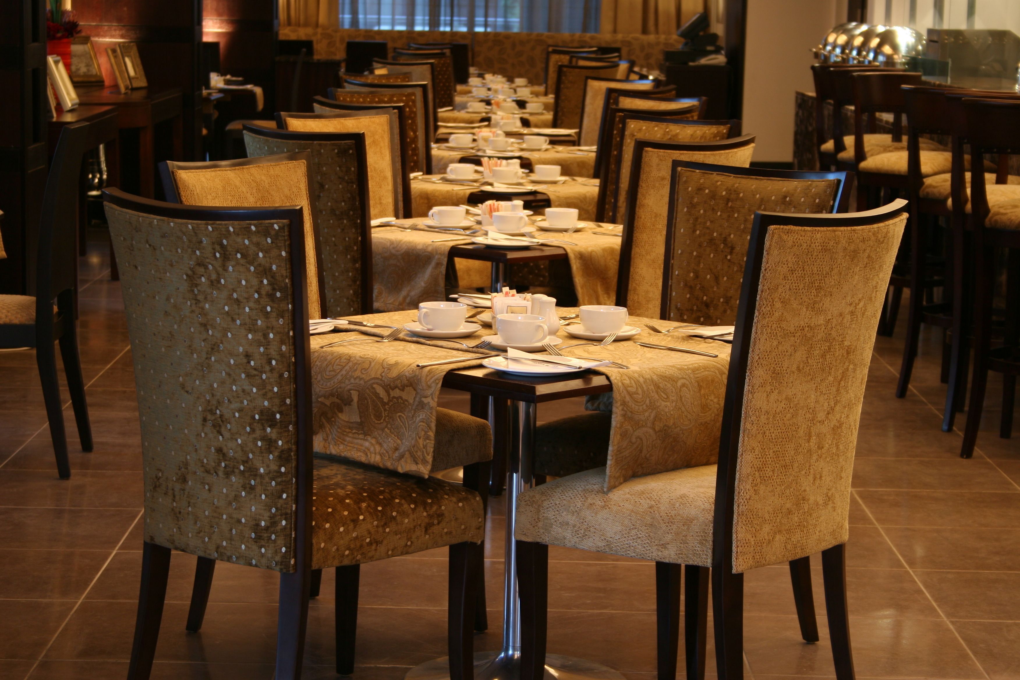 Une longue table à manger, entourée de chaises, préparée pour un repas.