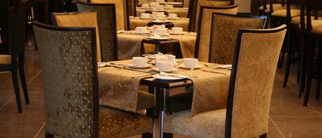 A long dining table with chairs, set for a meal.