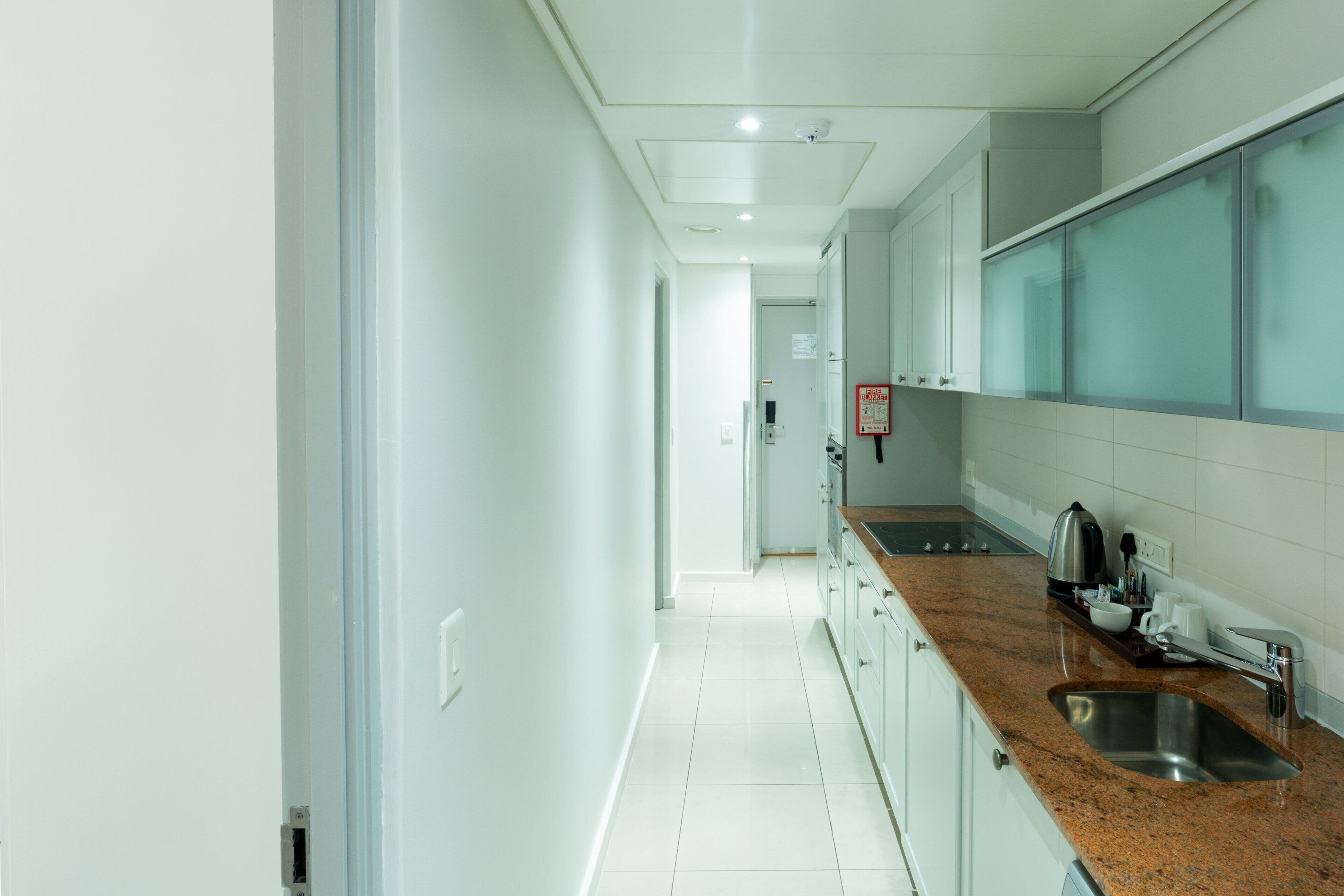 A modern kitchen with white cabinets, a granite countertop, and stainless steel appliances.