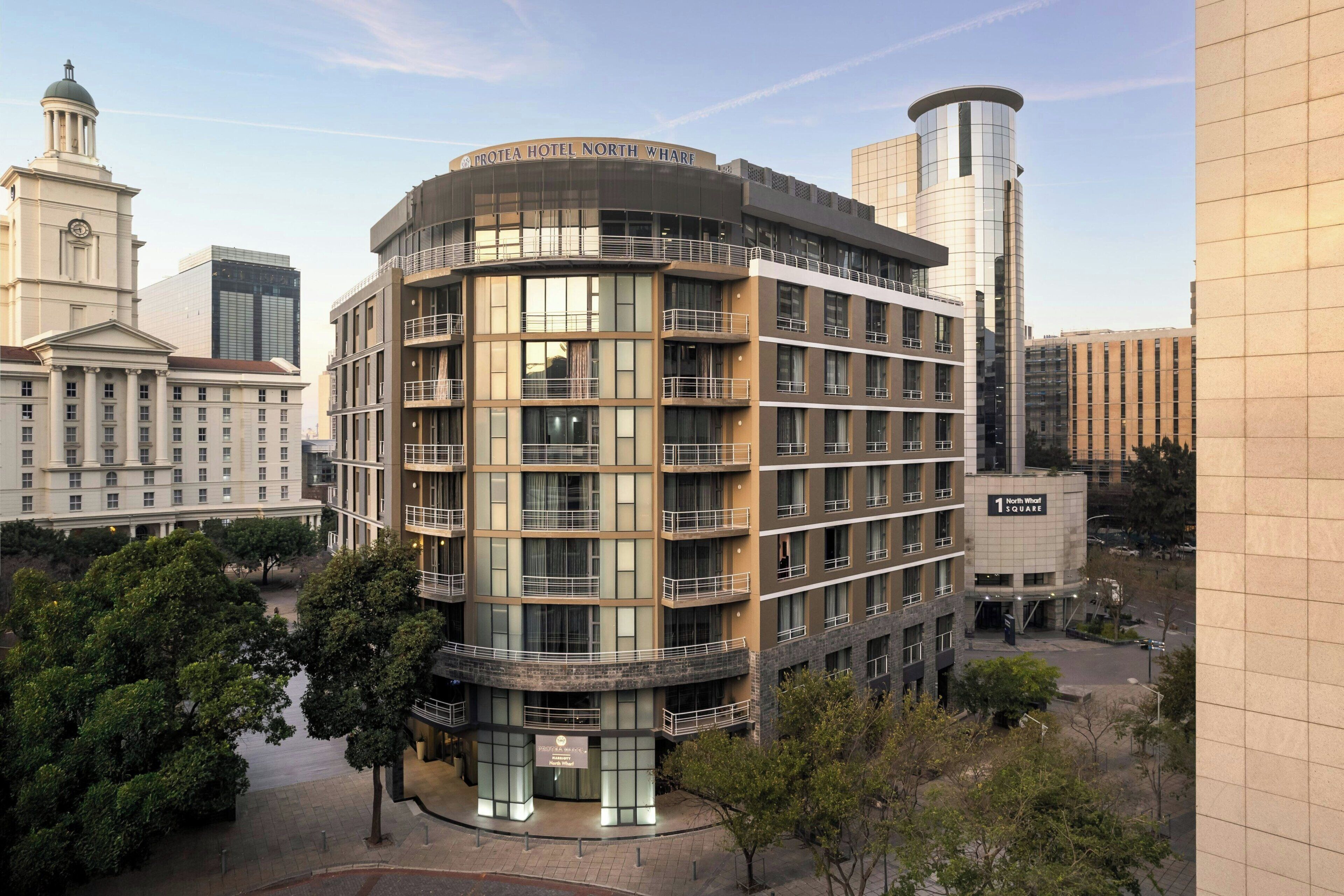 A multi-story hotel with a modern design, featuring balconies and large windows.