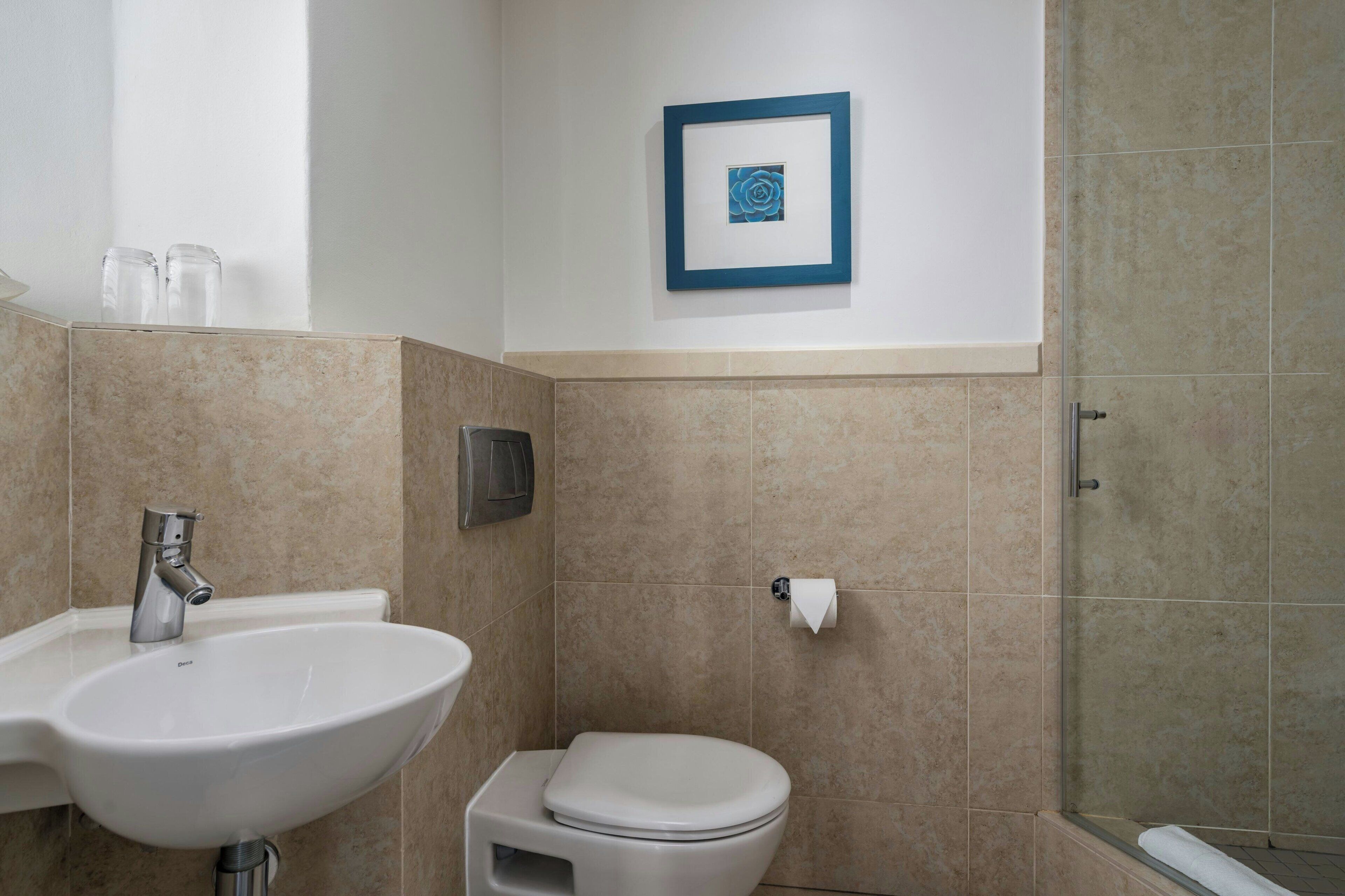 Ein Badezimmer mit Waschbecken, Toilette und Dusche.