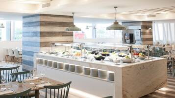 Un restaurante moderno con una isla buffet central, techo de madera y sillas verdes.
