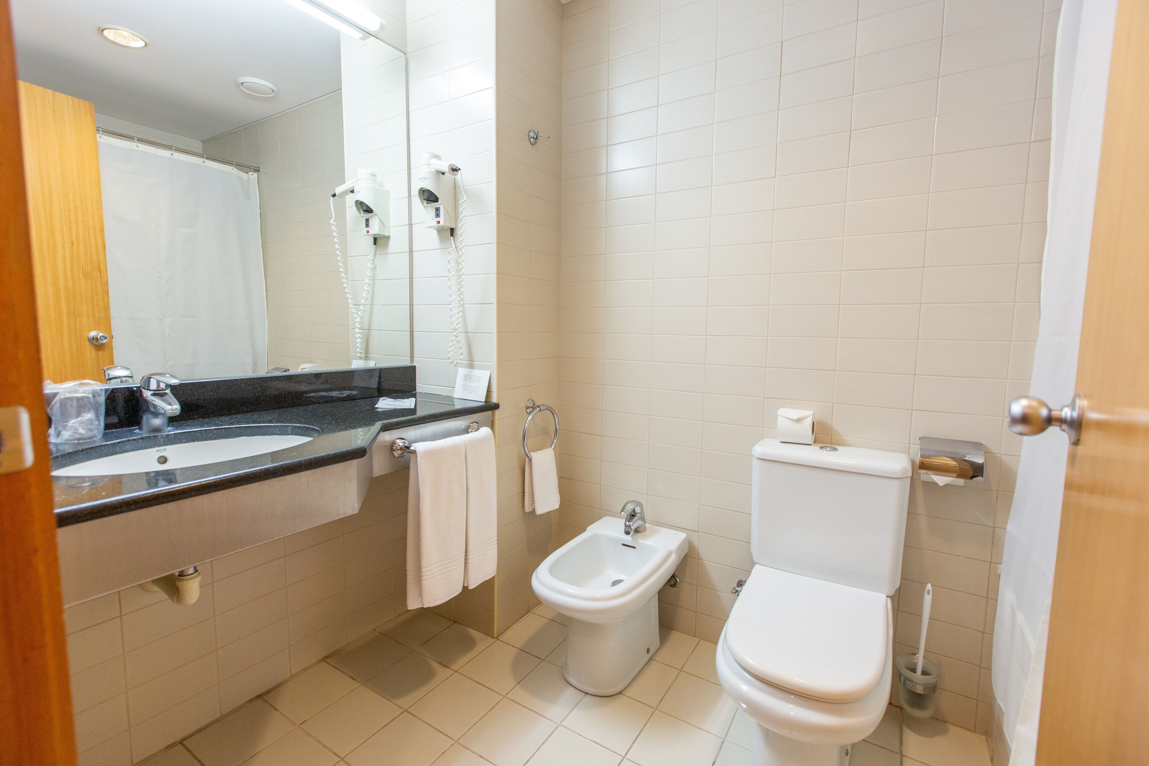 Badkamer | Een bad, een haardroger, een bidet, handdoeken