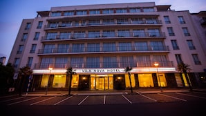 A multi-story hotel with a prominent entrance and a sign reading "Vila Nova Hotel". - MS Vila Nova (Ponta Delgada)