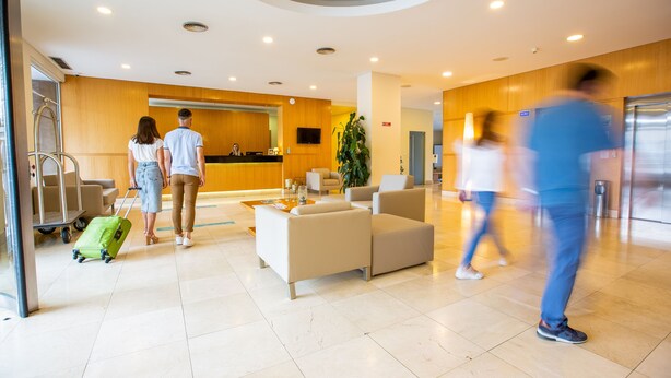 A modern lobby with a reception desk, seating area, and a staircase. - MS Vila Nova (Ponta Delgada)
