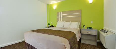 Una habitación de hotel con una cama, mesitas de noche, una lámpara y un calentador fijado a la pared.