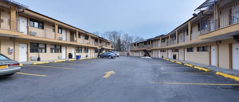 Una hilera de edificios de motel con un estacionamiento al frente.