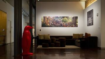 Een modern interieur met een groot abstract schilderij, een rode sculptuur en een modulaire bank.
