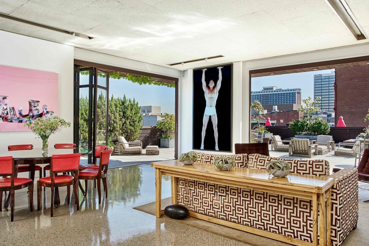 A modern interior with a dining area, a patterned bench, and a large window with a city view.