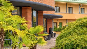Un edificio moderno con elementos arquitectónicos curvos, fachada de ladrillo y techo verde.