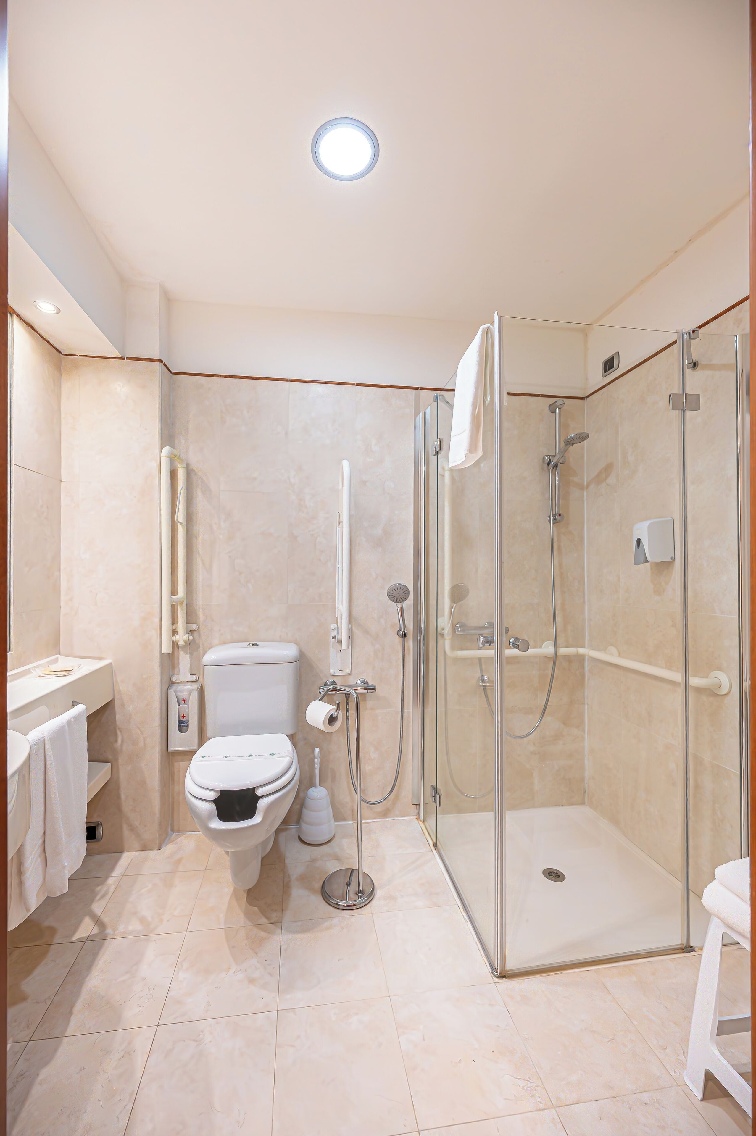 A bathroom with a toilet, bidet, and a glass-enclosed shower area.