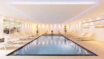 Una piscina cubierta, tumbonas