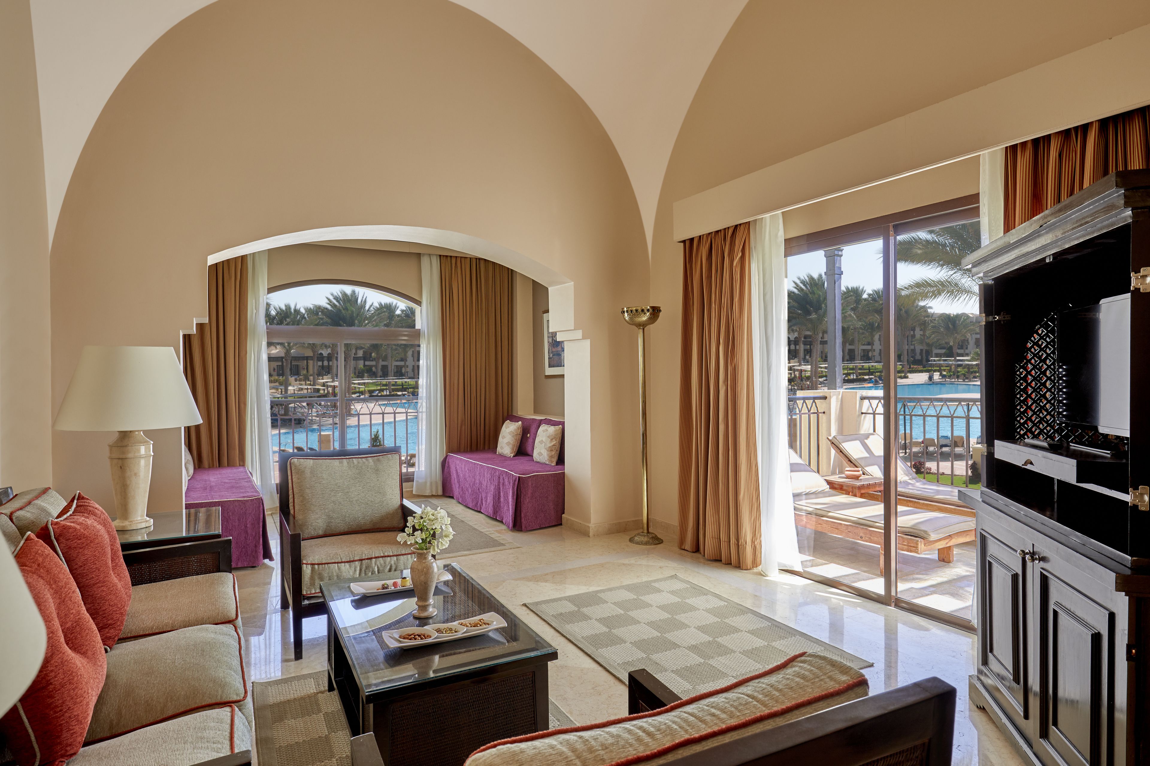 A spacious living room with a view of a pool and outdoor seating area.