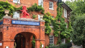 A red lion statue on a brick building with a sign reading "The Relais Henley at the Red Lion." - The Relais Henley (Henley-on-Thames)