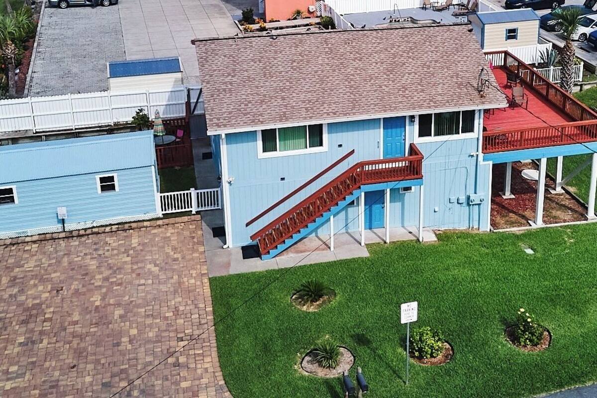 A two-story house with a red staircase, a blue exterior, and a small porch.