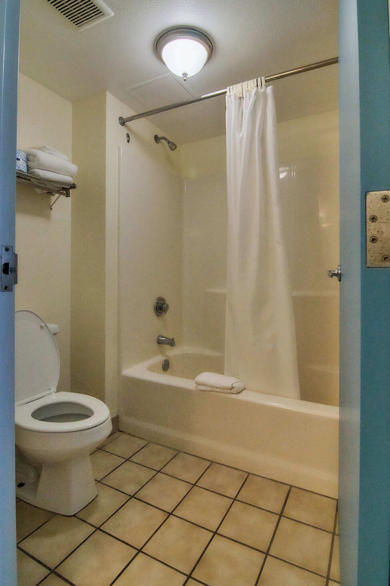 Une salle de bain équipée de toilettes, d’une baignoire et d’un rideau de douche.