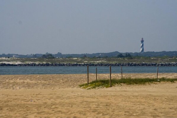 A beach with a lighthouse in the distance.