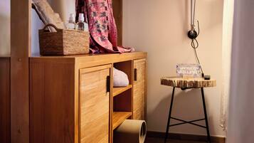 A wooden cabinet with shelves, a small table with a sign, and a lamp.