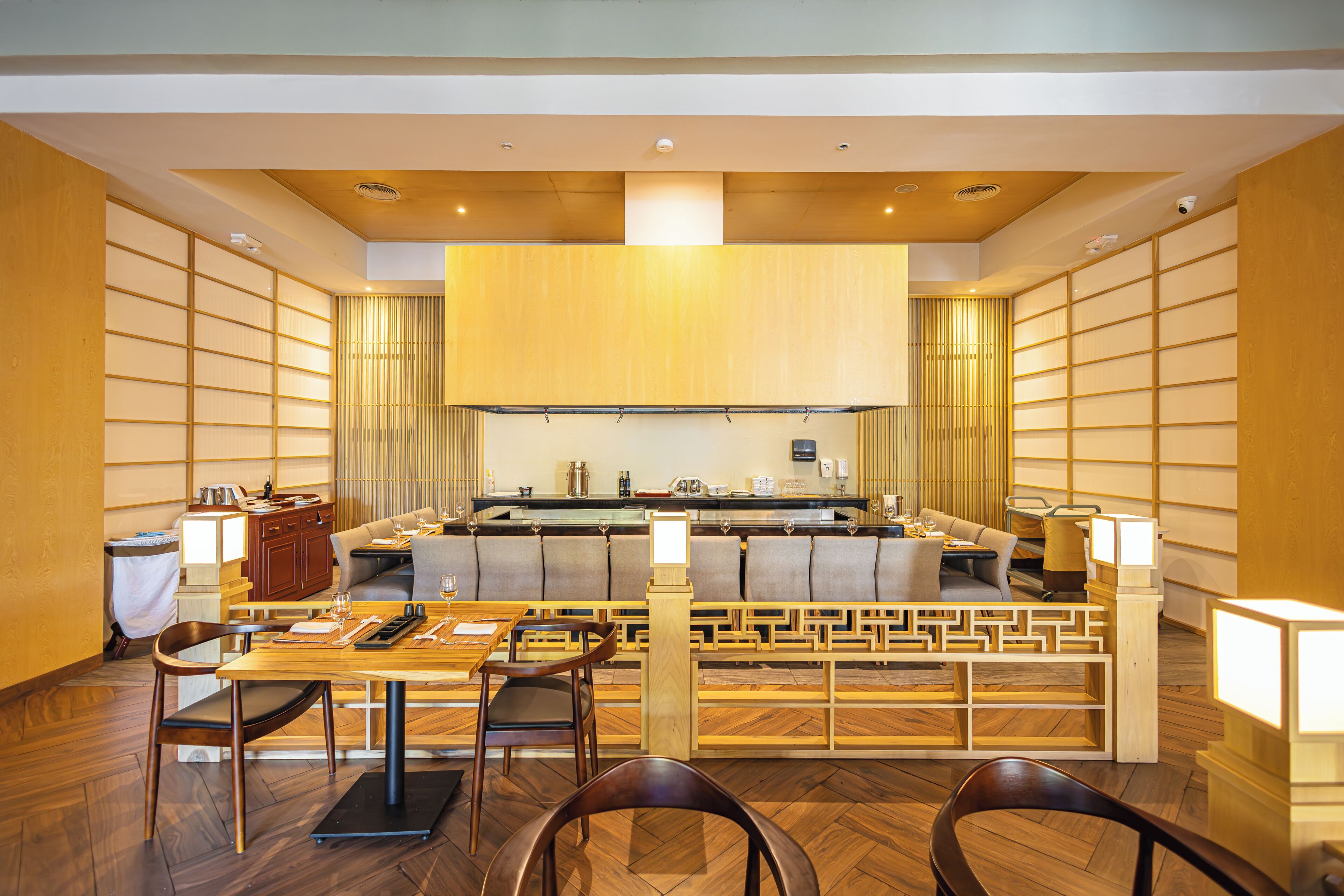 A modern restaurant with a central island, wooden furniture, and a clean, contemporary design.