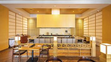 A modern restaurant with a central island, wooden furniture, and a clean, contemporary design.