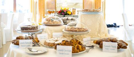 Ein reichhaltiges Buffet mit verschiedenen gekennzeichneten Gebäck- und Dessertspeisen.