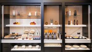 A buffet setup with various food items and condiments. - Savhotel Fiera Bologna (Bologna)