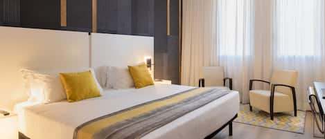 Una habitación de hotel moderna con una cama grande, un escritorio y una silla.