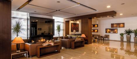 A modern living room with a fireplace, comfortable seating, and a dining area.