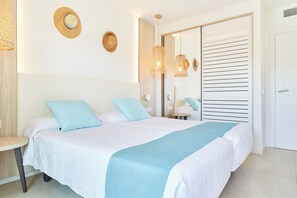 A neatly arranged bedroom with a bed, bedside tables, and a wardrobe. - Apartamentos San Miguel Park & Esmeralda Mar (Sant Joan de Labritja)