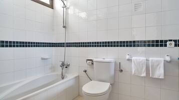 Un baño con bañera, inodoro y perchero para toallas.